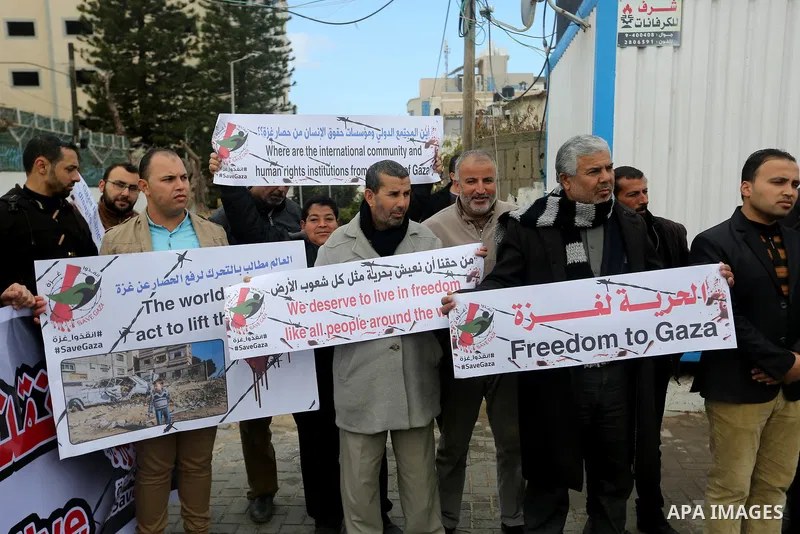Palestinians hold banners during a protest against froze tens of millions of dollars in contributions to the United Nations Relief and Work Agency (UNRWA), and Israeli blockade on Gaza strip, in front of the headquarter...