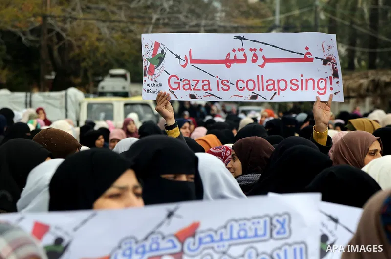 Palestinians hold banners during a protest against froze tens of millions of dollars in contributions to the United Nations Relief and Work Agency (UNRWA), and Israeli blockade on Gaza strip, in front of the headquarter...
