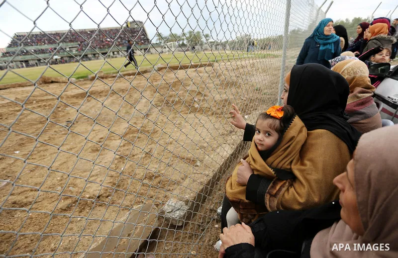 Palestinian women watch the football match between Al-Nuseirat and Al-Jalaa standing outside the fence of the stadium, at Nuseirat refugee camp, in the central of Gaza Strip, on January 28, 2018. Palestinian police allow...