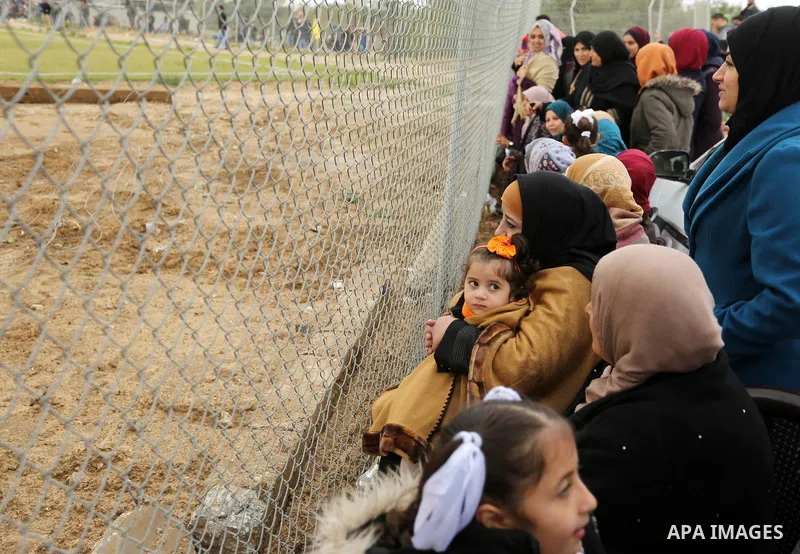 Palestinian women watch the football match between Al-Nuseirat and Al-Jalaa standing outside the fence of the stadium, at Nuseirat refugee camp, in the central of Gaza Strip, on January 28, 2018. Palestinian police allow...