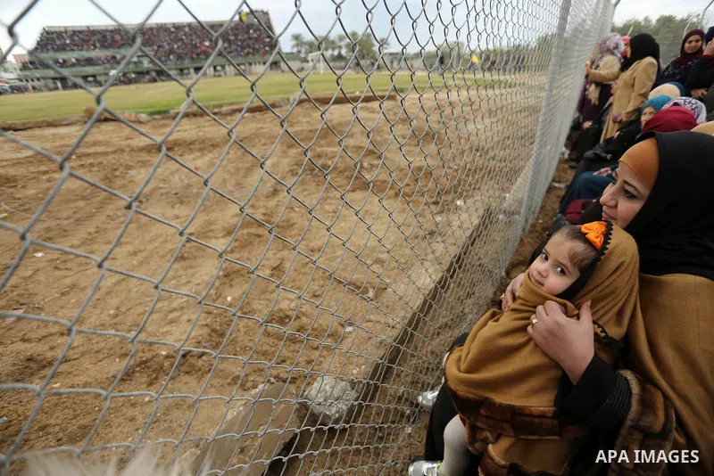 Palestinian women watch the football match between Al-Nuseirat and Al-Jalaa standing outside the fence of the stadium, at Nuseirat refugee camp, in the central of Gaza Strip, on January 28, 2018. Palestinian police allow...