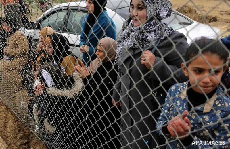Palestinian women watch the football match between Al-Nuseirat and Al-Jalaa standing outside the fence of the stadium, at Nuseirat refugee camp, in the central of Gaza Strip, on January 28, 2018. Palestinian police allow...