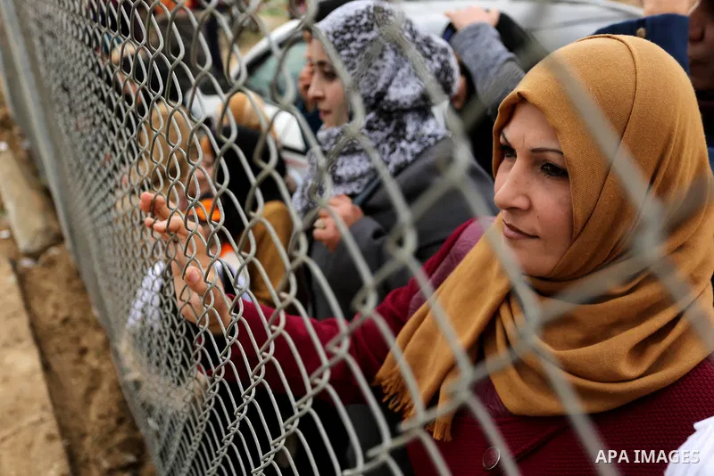 Palestinian women watch the football match between Al-Nuseirat and Al-Jalaa standing outside the fence of the stadium, at Nuseirat refugee camp, in the central of Gaza Strip, on January 28, 2018. Palestinian police allow...