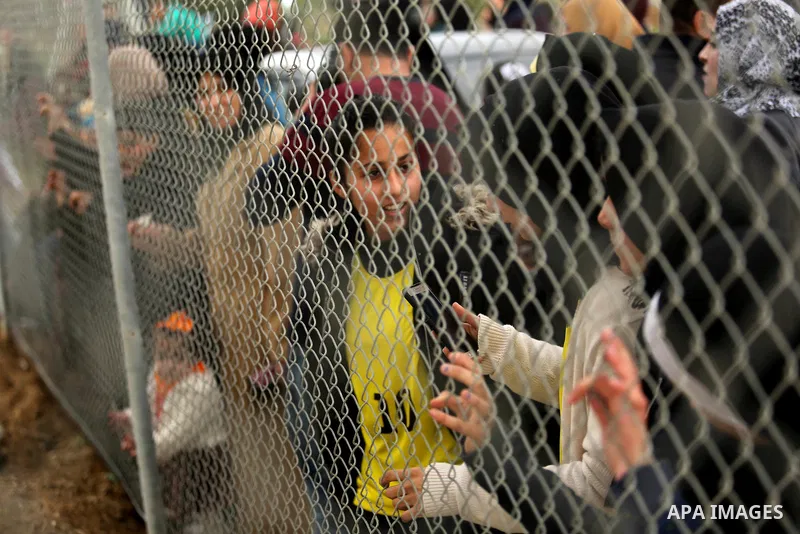 Palestinian women watch the football match between Al-Nuseirat and Al-Jalaa standing outside the fence of the stadium, at Nuseirat refugee camp, in the central of Gaza Strip, on January 28, 2018. Palestinian police allow...