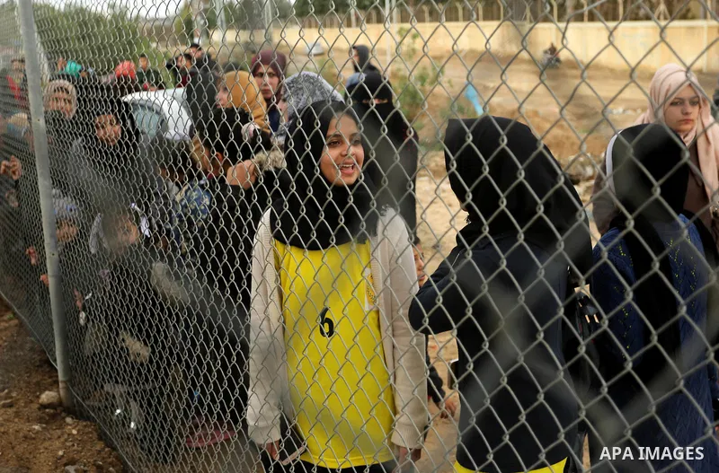 Palestinian women watch the football match between Al-Nuseirat and Al-Jalaa standing outside the fence of the stadium, at Nuseirat refugee camp, in the central of Gaza Strip, on January 28, 2018. Palestinian police allow...