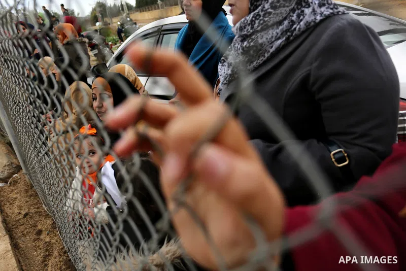 Palestinian women watch the football match between Al-Nuseirat and Al-Jalaa standing outside the fence of the stadium, at Nuseirat refugee camp, in the central of Gaza Strip, on January 28, 2018. Palestinian police allow...