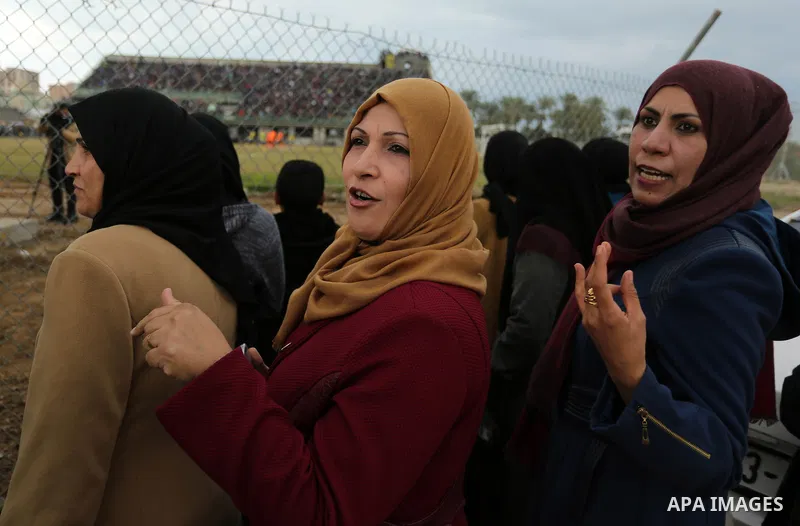 Palestinian women watch the football match between Al-Nuseirat and Al-Jalaa standing outside the fence of the stadium, at Nuseirat refugee camp, in the central of Gaza Strip, on January 28, 2018. Palestinian police allow...