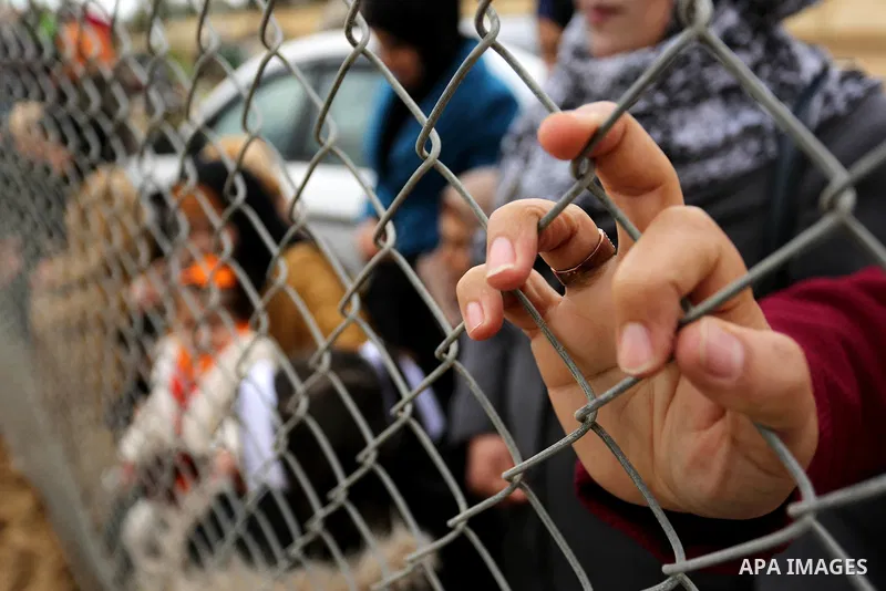 Palestinian women watch the football match between Al-Nuseirat and Al-Jalaa standing outside the fence of the stadium, at Nuseirat refugee camp, in the central of Gaza Strip, on January 28, 2018. Palestinian police allow...