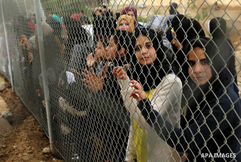 Palestinian women watch the football match between Al-Nuseirat and Al-Jalaa standing outside the fence of the stadium, at Nuseirat refugee camp, in the central of Gaza Strip, on January 28, 2018. Palestinian police allow...