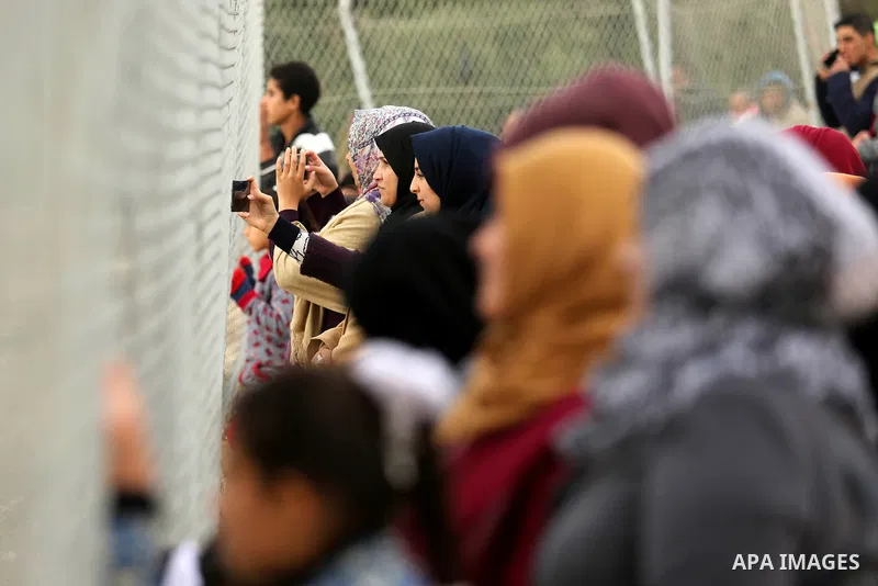 Palestinian women watch the football match between Al-Nuseirat and Al-Jalaa standing outside the fence of the stadium, at Nuseirat refugee camp, in the central of Gaza Strip, on January 28, 2018. Palestinian police allow...
