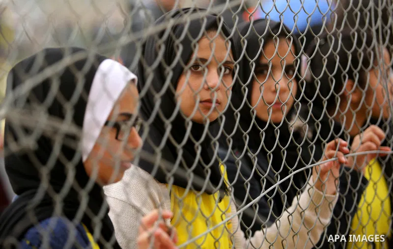Palestinian women watch the football match between Al-Nuseirat and Al-Jalaa standing outside the fence of the stadium, at Nuseirat refugee camp, in the central of Gaza Strip, on January 28, 2018. Palestinian police allow...