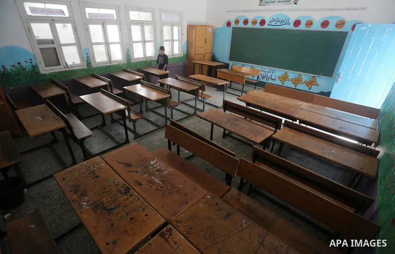 A Palestinian boy stands inside a closed school during the strike against froze tens of millions of dollars in contributions to the United Nations Relief and Work Agency (UNRWA), in Gaza city on January 29, 2018. Photo b...