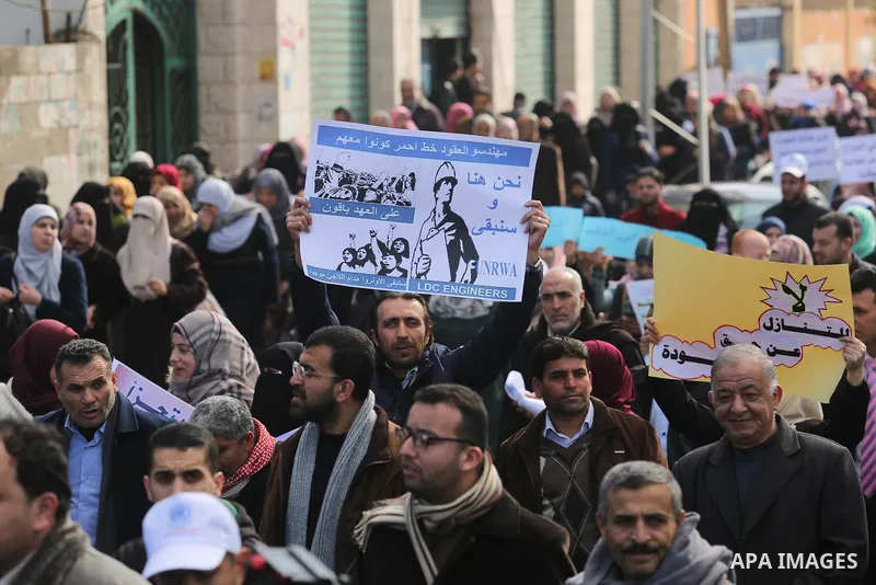 Palestinian employee of United Nations Relief and Works Agency (UNRWA) hold a sign during a protest against a U.S. decision to cut aid, in Gaza City January 29, 2018. Photo by Ashraf Amra