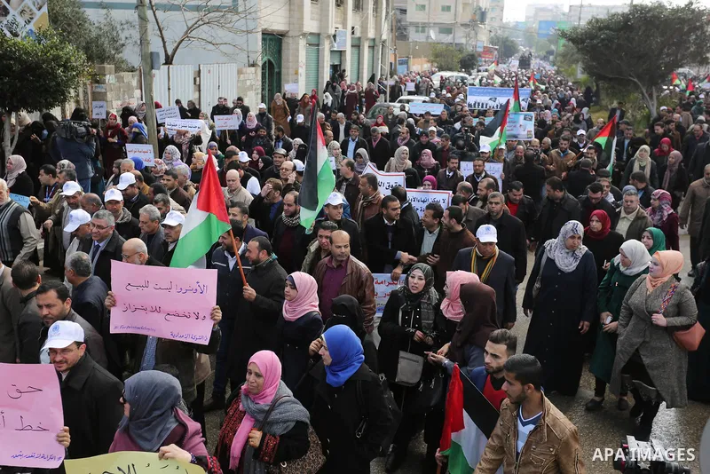 Palestinian employee of United Nations Relief and Works Agency (UNRWA) hold a sign during a protest against a U.S. decision to cut aid, in Gaza City January 29, 2018. Photo by Ashraf Amra