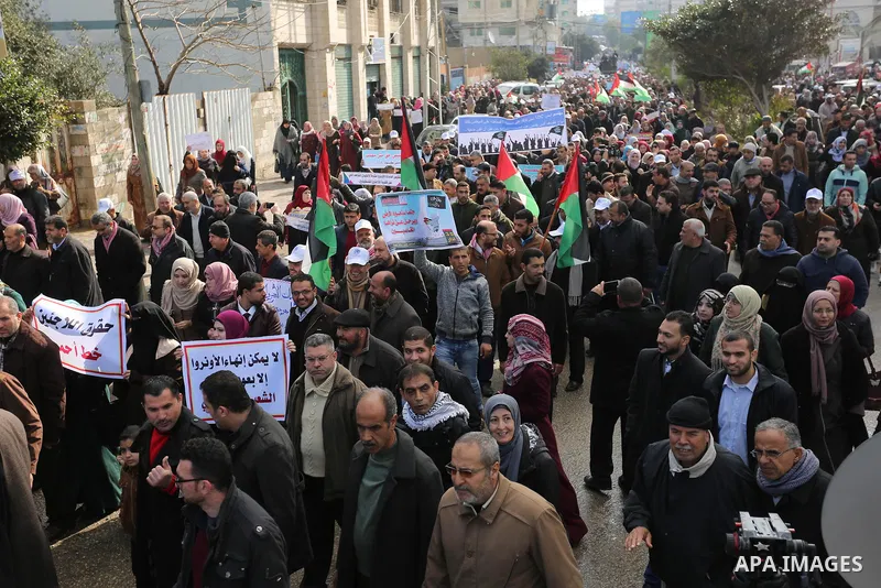 Palestinian employee of United Nations Relief and Works Agency (UNRWA) hold a sign during a protest against a U.S. decision to cut aid, in Gaza City January 29, 2018. Photo by Ashraf Amra
