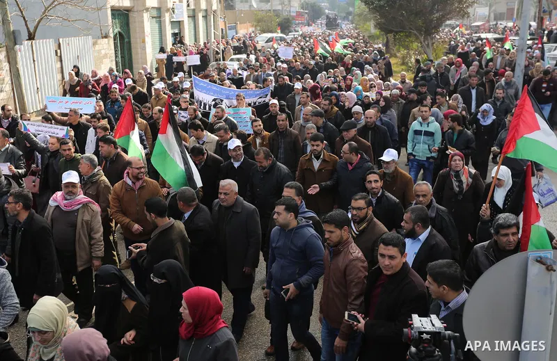 Palestinian employee of United Nations Relief and Works Agency (UNRWA) hold a sign during a protest against a U.S. decision to cut aid, in Gaza City January 29, 2018. Photo by Ashraf Amra