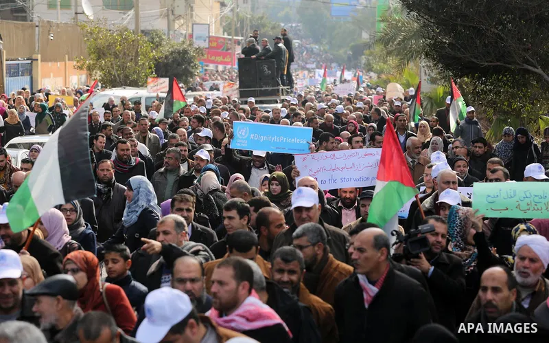 Palestinian employee of United Nations Relief and Works Agency (UNRWA) hold a sign during a protest against a U.S. decision to cut aid, in Gaza City January 29, 2018. Photo by Ashraf Amra