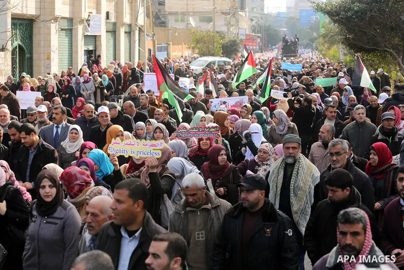 Palestinian employee of United Nations Relief and Works Agency (UNRWA) hold a sign during a protest against a U.S. decision to cut aid, in Gaza City January 29, 2018. Photo by Ashraf Amra