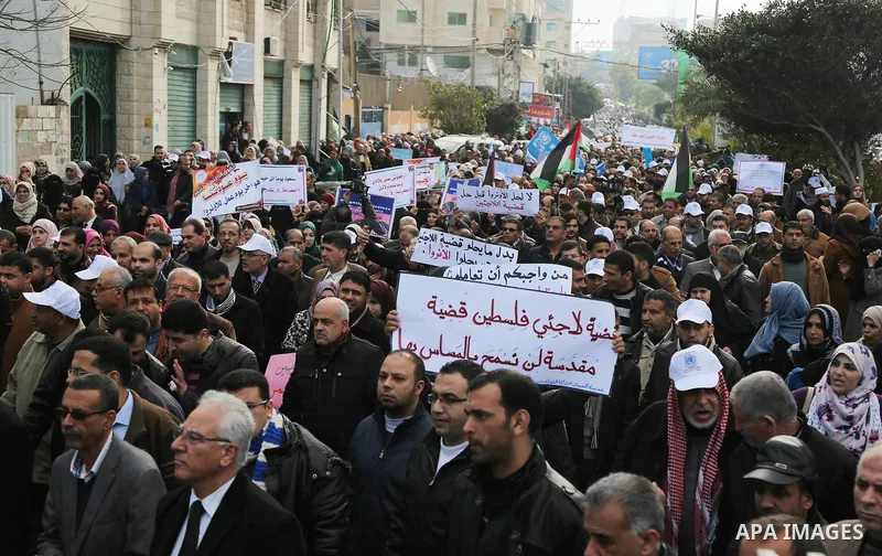 Palestinian employee of United Nations Relief and Works Agency (UNRWA) hold a sign during a protest against a U.S. decision to cut aid, in Gaza City January 29, 2018. Photo by Ashraf Amra