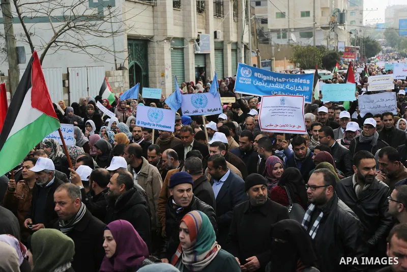 Palestinian employee of United Nations Relief and Works Agency (UNRWA) hold a sign during a protest against a U.S. decision to cut aid, in Gaza City January 29, 2018. Photo by Ashraf Amra