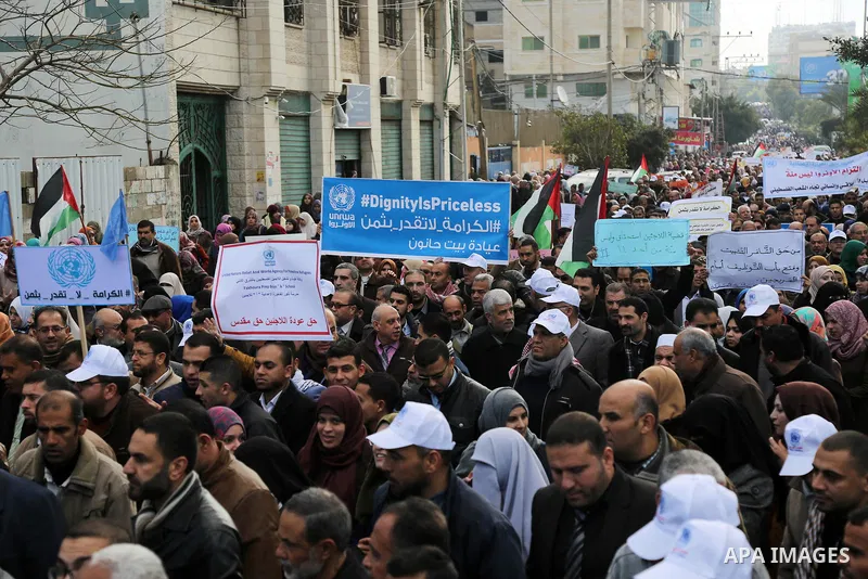 Palestinian employee of United Nations Relief and Works Agency (UNRWA) hold a sign during a protest against a U.S. decision to cut aid, in Gaza City January 29, 2018. Photo by Ashraf Amra