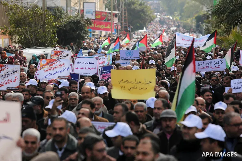 Palestinian employee of United Nations Relief and Works Agency (UNRWA) hold a sign during a protest against a U.S. decision to cut aid, in Gaza City January 29, 2018. Photo by Ashraf Amra