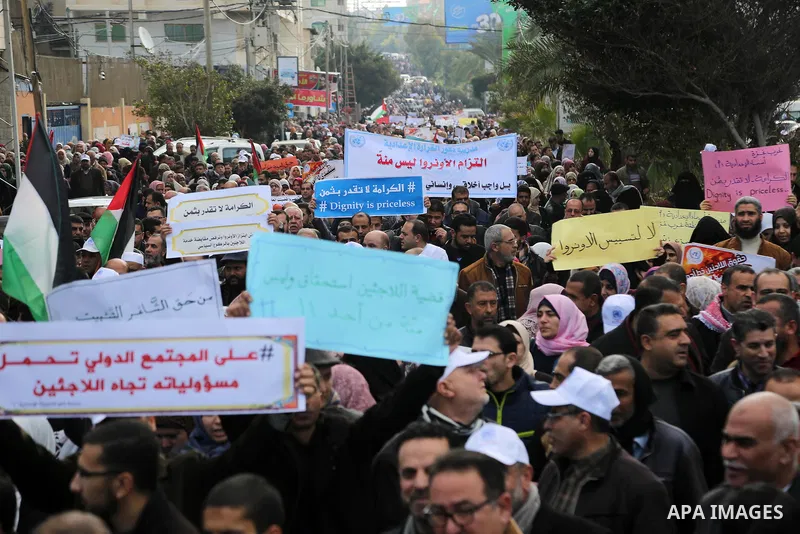 Palestinian employee of United Nations Relief and Works Agency (UNRWA) hold a sign during a protest against a U.S. decision to cut aid, in Gaza City January 29, 2018. Photo by Ashraf Amra