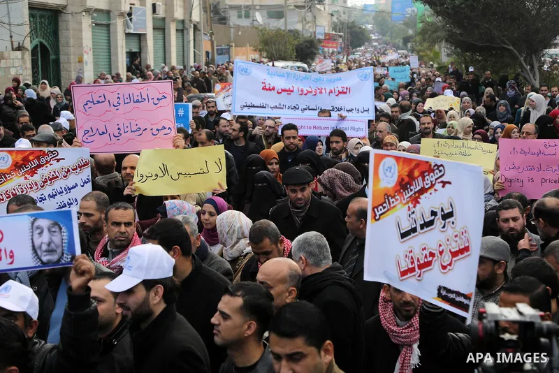 Palestinian employee of United Nations Relief and Works Agency (UNRWA) hold a sign during a protest against a U.S. decision to cut aid, in Gaza City January 29, 2018. Photo by Ashraf Amra