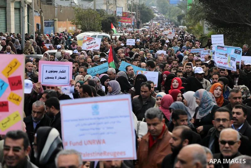 Palestinian employee of United Nations Relief and Works Agency (UNRWA) hold a sign during a protest against a U.S. decision to cut aid, in Gaza City January 29, 2018. Photo by Ashraf Amra