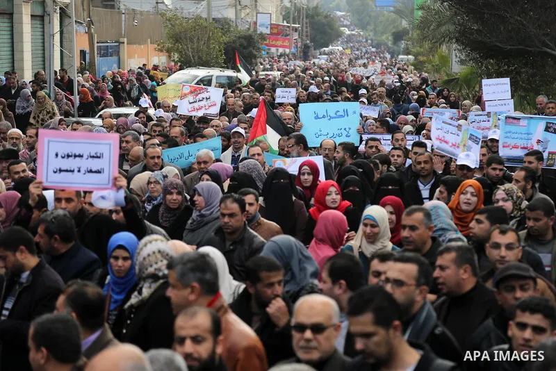 Palestinian employee of United Nations Relief and Works Agency (UNRWA) hold a sign during a protest against a U.S. decision to cut aid, in Gaza City January 29, 2018. Photo by Ashraf Amra