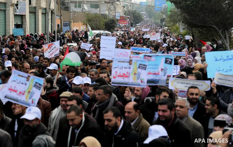 Palestinian employee of United Nations Relief and Works Agency (UNRWA) hold a sign during a protest against a U.S. decision to cut aid, in Gaza City January 29, 2018. Photo by Ashraf Amra