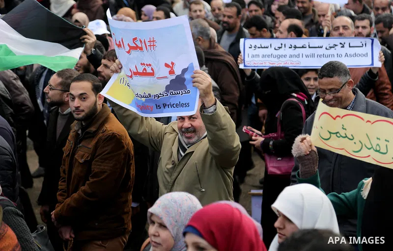 Palestinian employee of United Nations Relief and Works Agency (UNRWA) hold a sign during a protest against a U.S. decision to cut aid, in Gaza City January 29, 2018. Photo by Ashraf Amra