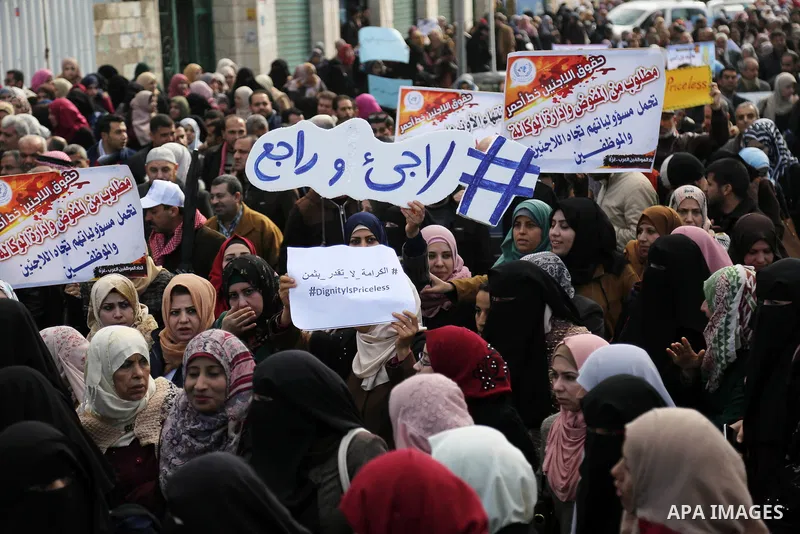 Palestinian employee of United Nations Relief and Works Agency (UNRWA) hold a sign during a protest against a U.S. decision to cut aid, in Gaza City January 29, 2018. Photo by Ashraf Amra