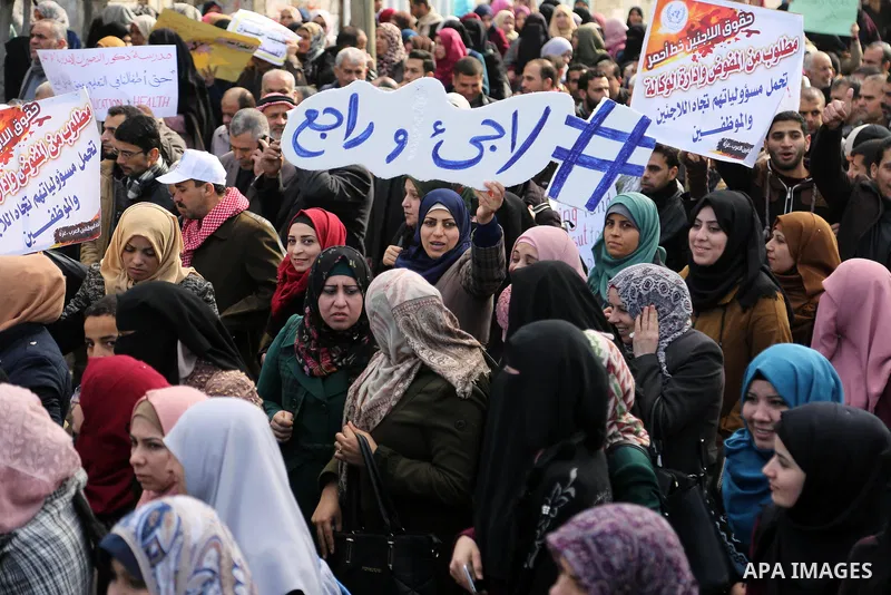 Palestinian employee of United Nations Relief and Works Agency (UNRWA) hold a sign during a protest against a U.S. decision to cut aid, in Gaza City January 29, 2018. Photo by Ashraf Amra