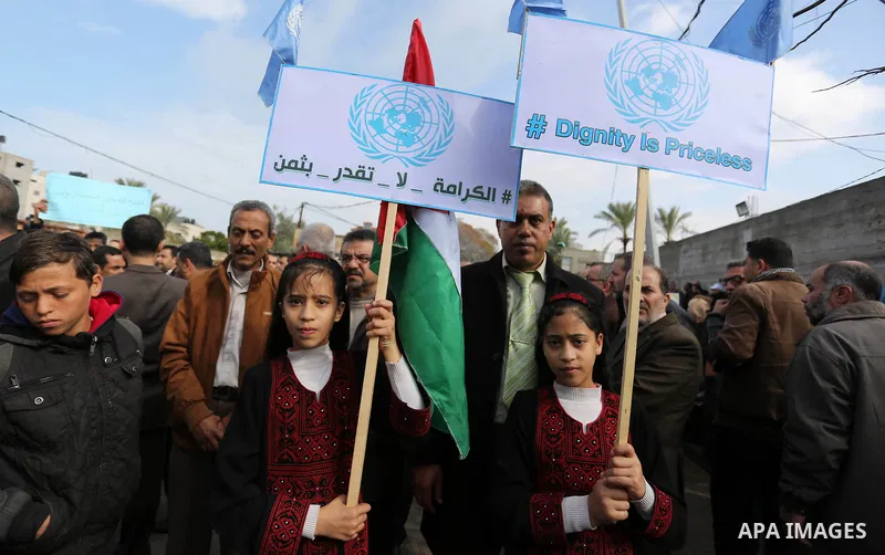 Palestinian employee of United Nations Relief and Works Agency (UNRWA) hold a sign during a protest against a U.S. decision to cut aid, in Gaza City January 29, 2018. Photo by Ashraf Amra