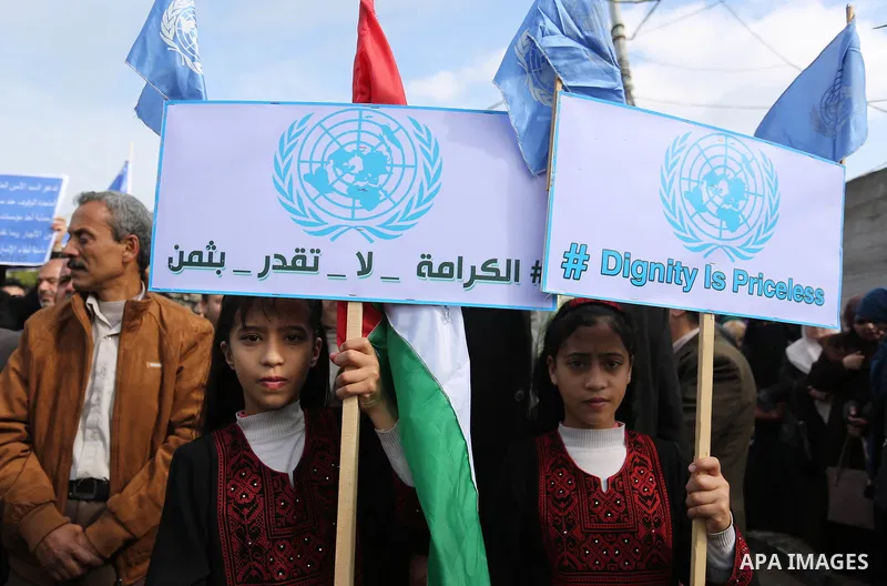 Palestinian employee of United Nations Relief and Works Agency (UNRWA) hold a sign during a protest against a U.S. decision to cut aid, in Gaza City January 29, 2018. Photo by Ashraf Amra
