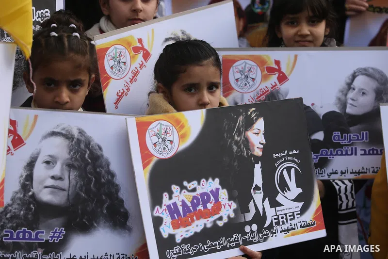 Palestinian children hold poster of teenager Ahed Tamimi, 16-year-old who held in Israeli jails during a protest to show solidarity with her, in front of Red cross office, in Gaza City January 29, 2018. Photo by Ashraf A...