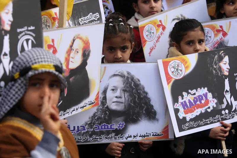Palestinian children hold poster of teenager Ahed Tamimi, 16-year-old who held in Israeli jails during a protest to show solidarity with her, in front of Red cross office, in Gaza City January 29, 2018. Photo by Ashraf A...