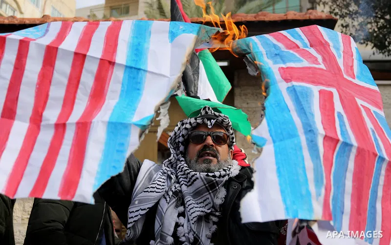 A Palestinian demonstrator burns an Israeli, British and U.S. flags during a protest in support of Palestinian teenager Ahed Tamimi, 16-year-old, in front of Red cross office, in Gaza City January 29, 2018. Photo by Ashr...