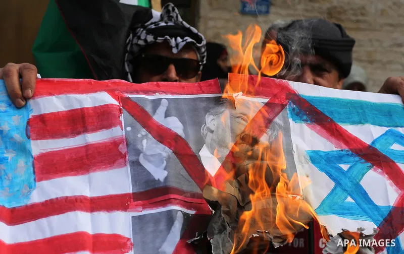 A Palestinian demonstrator burns an Israeli, British and U.S. flags during a protest in support of Palestinian teenager Ahed Tamimi, 16-year-old, in front of Red cross office, in Gaza City January 29, 2018. Photo by Ashr...