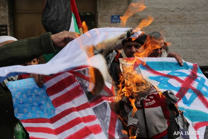 A Palestinian demonstrator burns an Israeli, British and U.S. flags during a protest in support of Palestinian teenager Ahed Tamimi, 16-year-old, in front of Red cross office, in Gaza City January 29, 2018. Photo by Ashr...