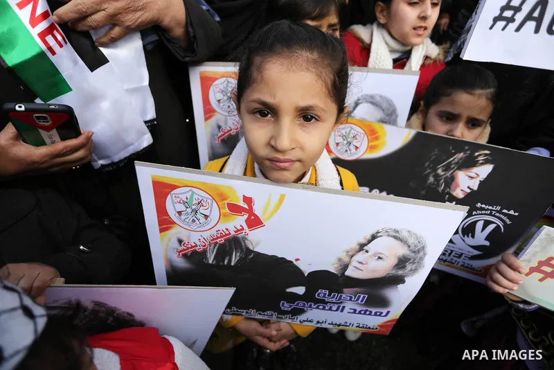 Palestinian children hold poster of teenager Ahed Tamimi, 16-year-old who held in Israeli jails during a protest to show solidarity with her, in front of Red cross office, in Gaza City January 29, 2018. Photo by Ashraf A...