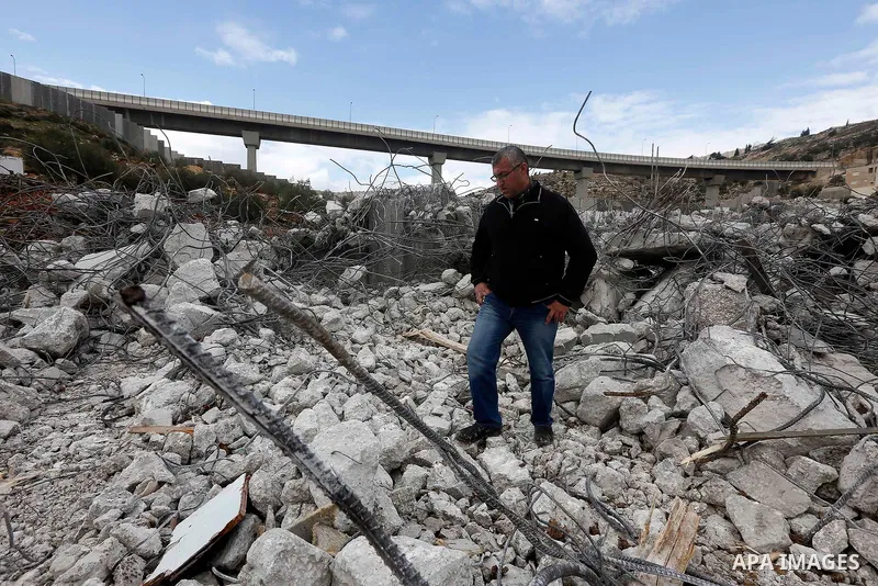 A Palestinian man stands on the rubble of two under-construction Palestinian residential buildings after they were demolished by Israeli bulldozers in the West Bank town of Biet Jala, near Bethlehem January 29, 2018. Pho...