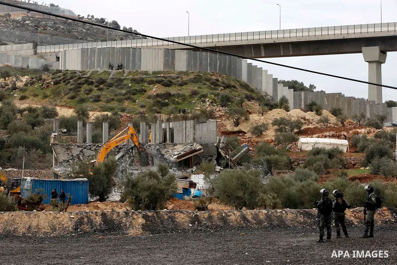 Israeli border police officers stand guard as Israeli machineries demolish an under-construction Palestinian residential building in the West Bank town of Biet Jala, near Bethlehem January 29, 2018. Photo by Wisam Hashla...