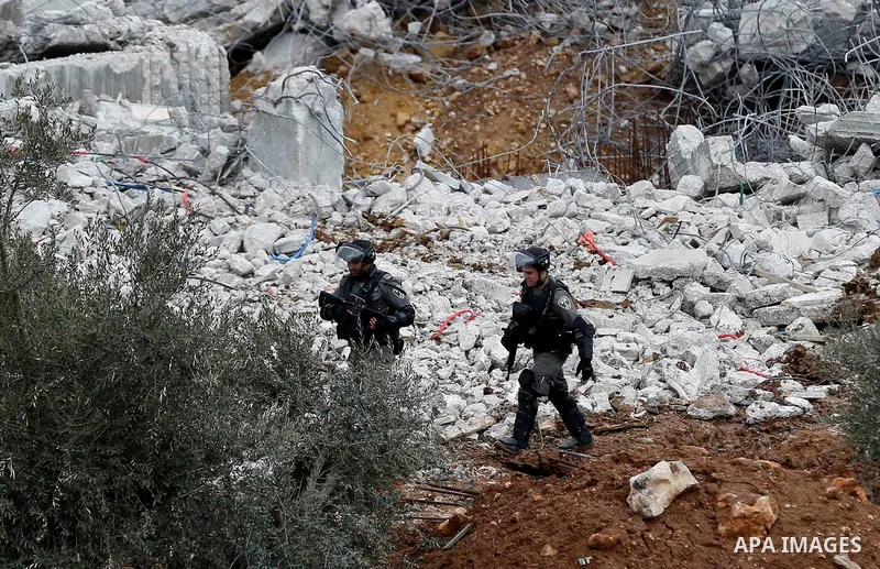 Israeli border police officers stand guard as Israeli machineries demolish an under-construction Palestinian residential building in the West Bank town of Biet Jala, near Bethlehem January 29, 2018. Photo by Wisam Hashla...