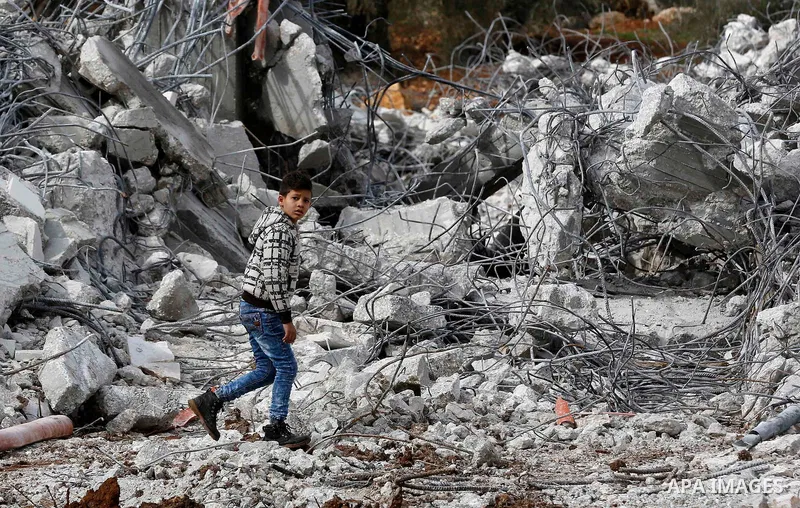 A Palestinian boy walks on the rubble of two under-construction Palestinian residential buildings after they were demolished by Israeli bulldozers in the West Bank town of Biet Jala, near Bethlehem January 29, 2018. Phot...