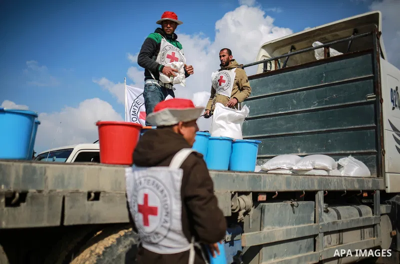 A Palestinian farmer, who his farm near the Israeli border fills up a plastic bucket with wheat seeds during a tour by the International Committee of the Red Cross (ICRC), near the border with Israel, in Rafah in the sou...