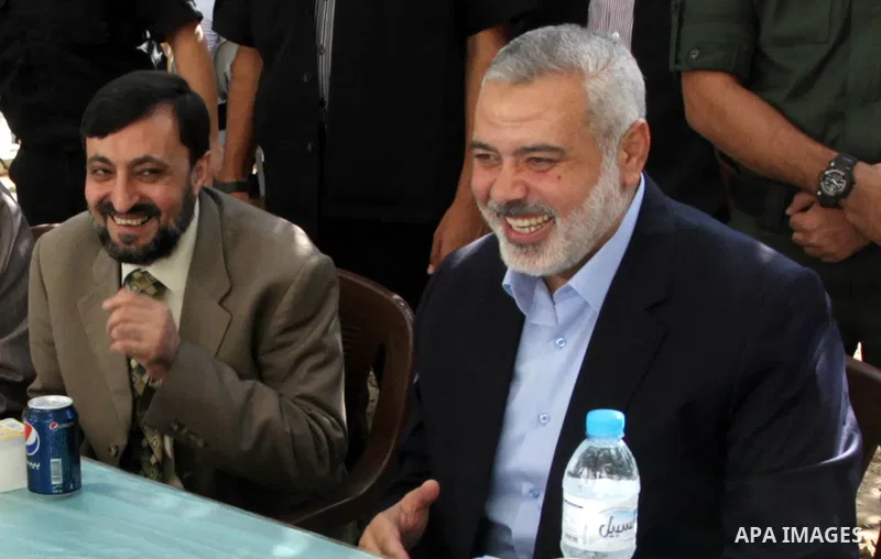 (FILES) This file photo taken on November 15, 2013 shows Hamas senior leader Imad al-Alami sits beside Hamas chief Ismail Haniyeh in Gaza city. Al-Alami who died Tuesday, January 30, 2018 of his injuries while inspecting...