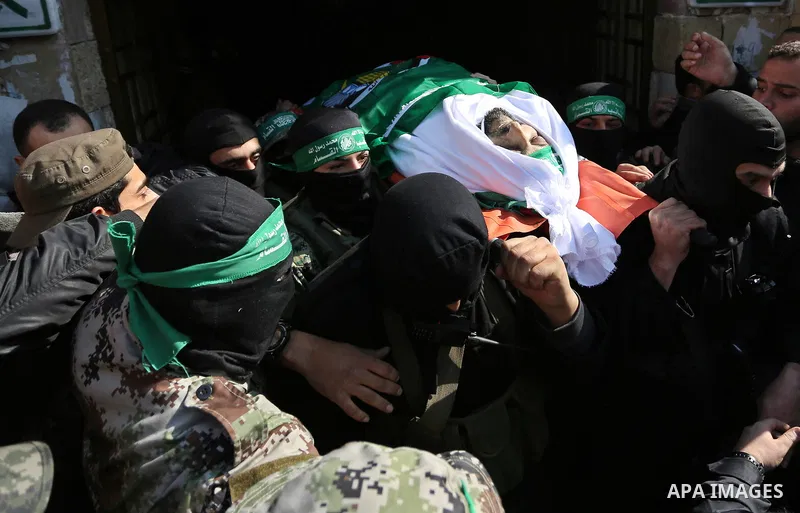 Palestinian militants from the Ezzedine al-Qassam Brigades, the armed wing of the Hamas movement carry the body of Hamas senior leader Imad al-Alami during his funeral outside the al-Omari mosque in Gaza City on January...