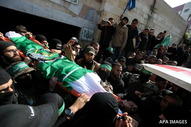 Palestinian militants from the Ezzedine al-Qassam Brigades, the armed wing of the Hamas movement carry the body of Hamas senior leader Imad al-Alami during his funeral outside the al-Omari mosque in Gaza City on January...